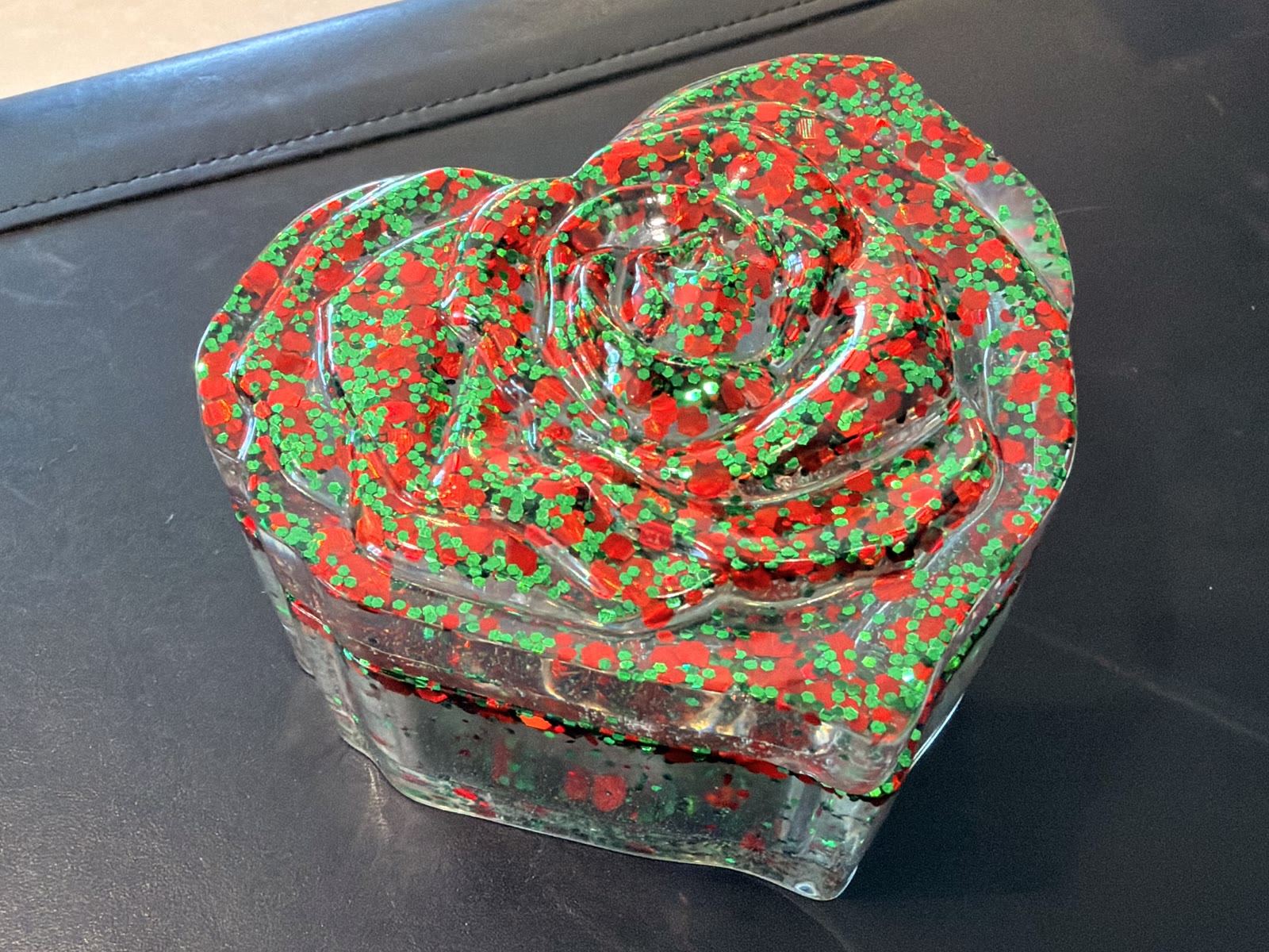 Heart-shaped clear resin trinket box with a 3D rose lid filled with red and green glitter